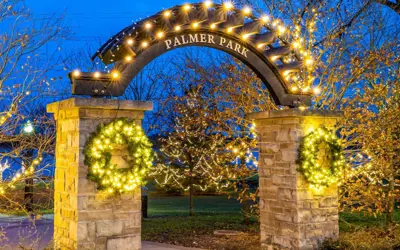 archway in front of Palmer Park with Christmas decorations and lights during the evening