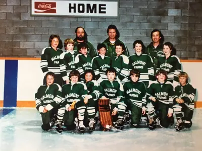 Malmont Farms Team in green jerseys standing on ice in front of home bench