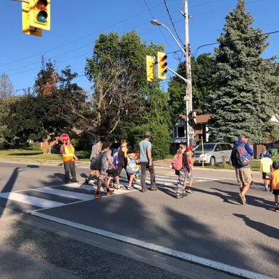 Kids Crossing the road with a crossing guard 