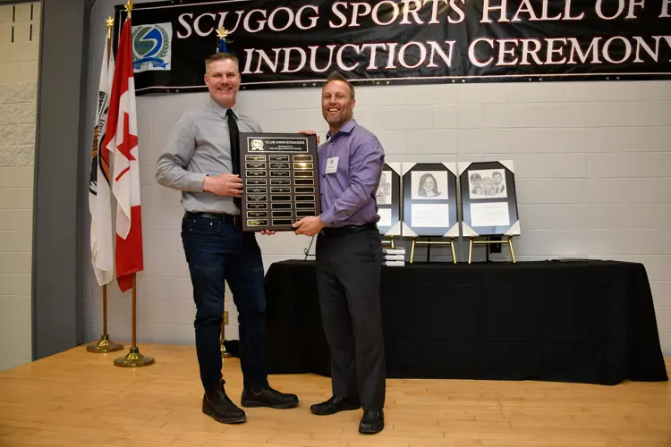 Hall of Fame committee member presenting anniversary plaque