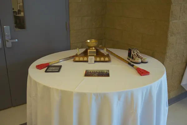 display with trophy, shoes, brooms and photos