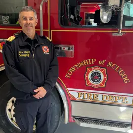 Mike Matthews standing in front of Scugog Firetruck