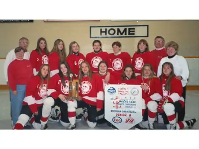 IGA Ringette team in red jerseys standing on ice in front of home bench